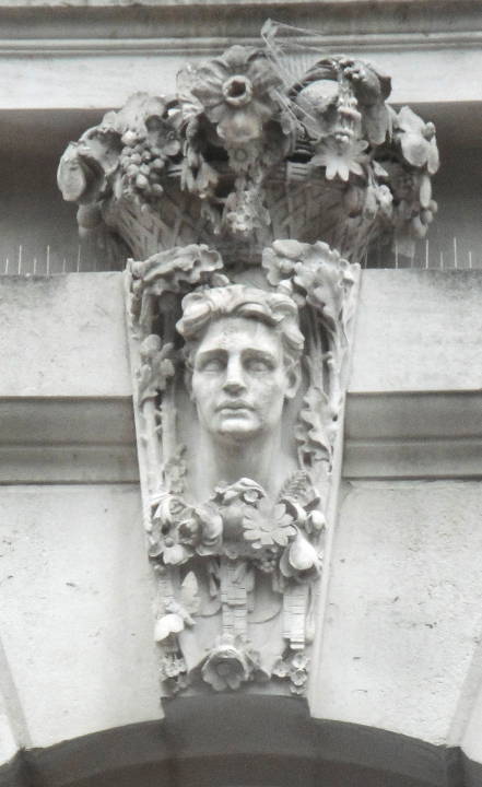 Keystone with  man with curly hair surrounded” by flowers